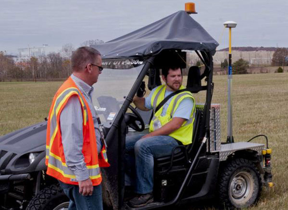 A man riding a car and a man standing beside it