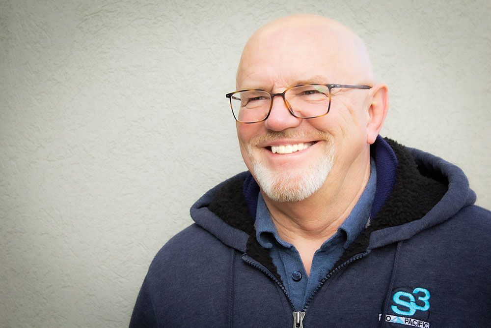 Mike Dillon Smiling Portrait in a Blue Hoodie