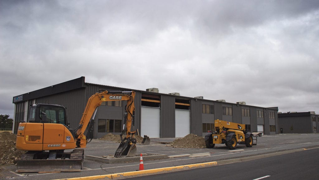 Two excavators outside a building